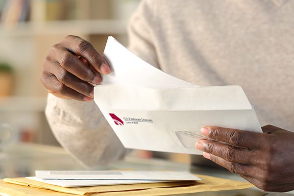 Man opening a letter from the Georgia Eminent Domain Law Office.
