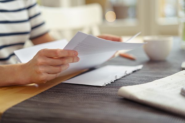 Woman opening a letter from the department of transportation.