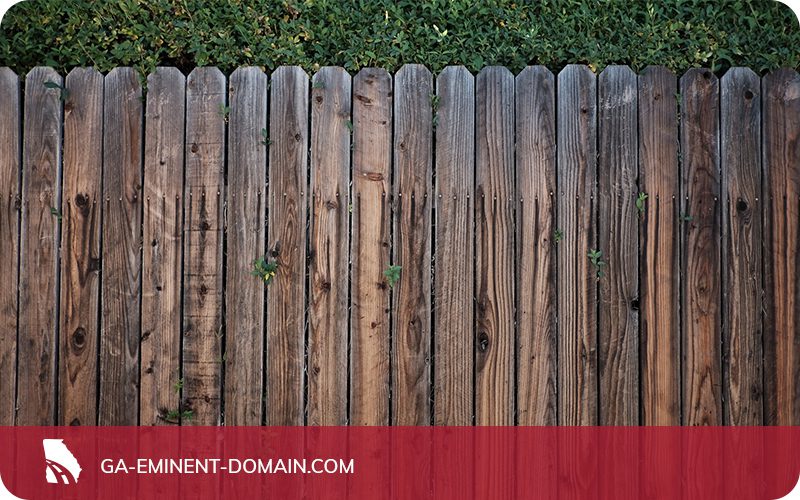 A privacy fence in a backyard made of wooden boards.