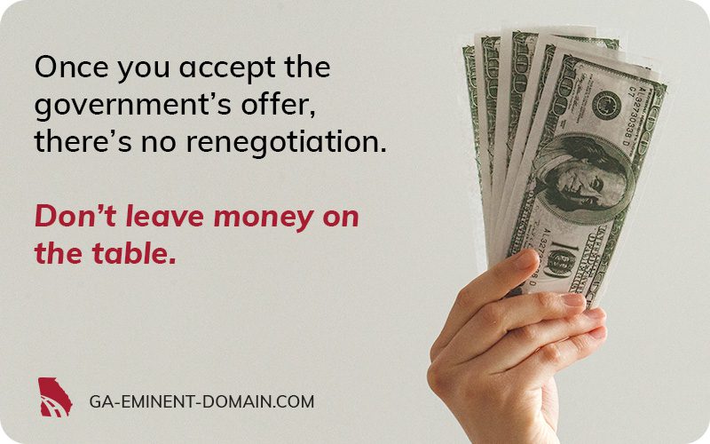 A hand holding up several $100 dollar bills.